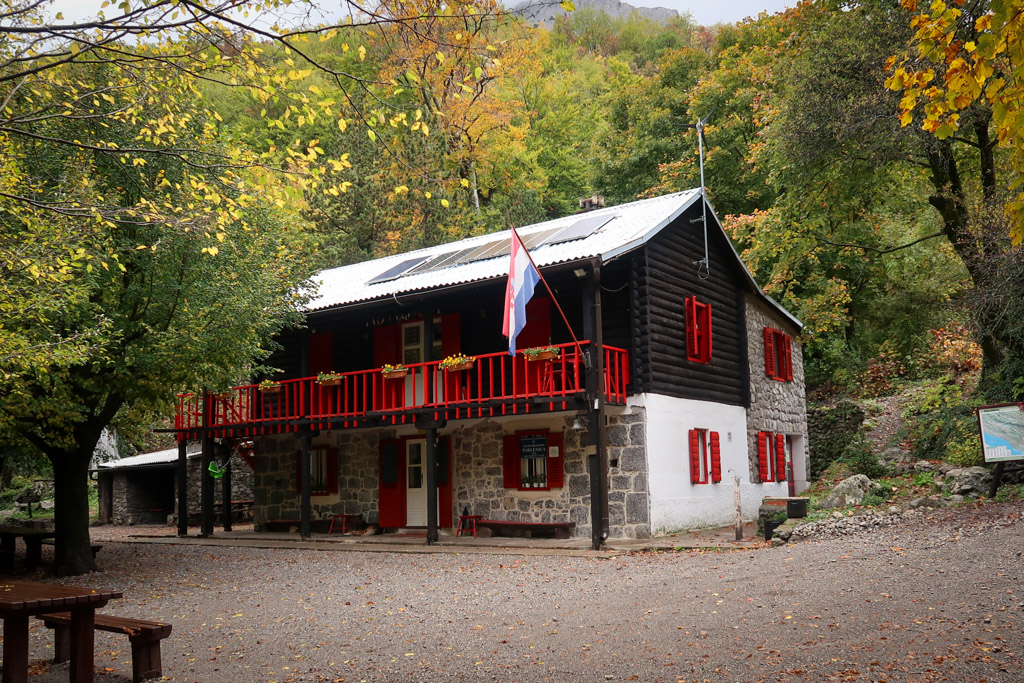 Paklenica Mountain Hut nestle in the woods and brightly painted with red and white