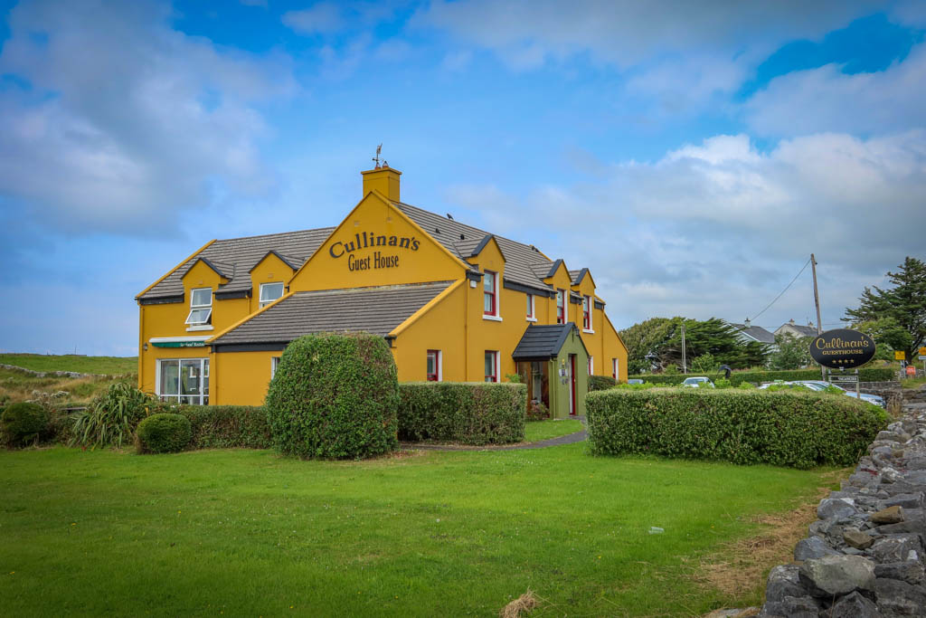 Cullinan's Guest House is a bright yellow sprawling home with a green entry way and a stone fence out front. Catch the Galway to Doolin bus here.