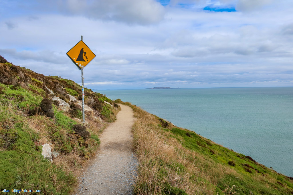 A sign warning of a crumbling cliff's edge along the Howth Cliff Walk