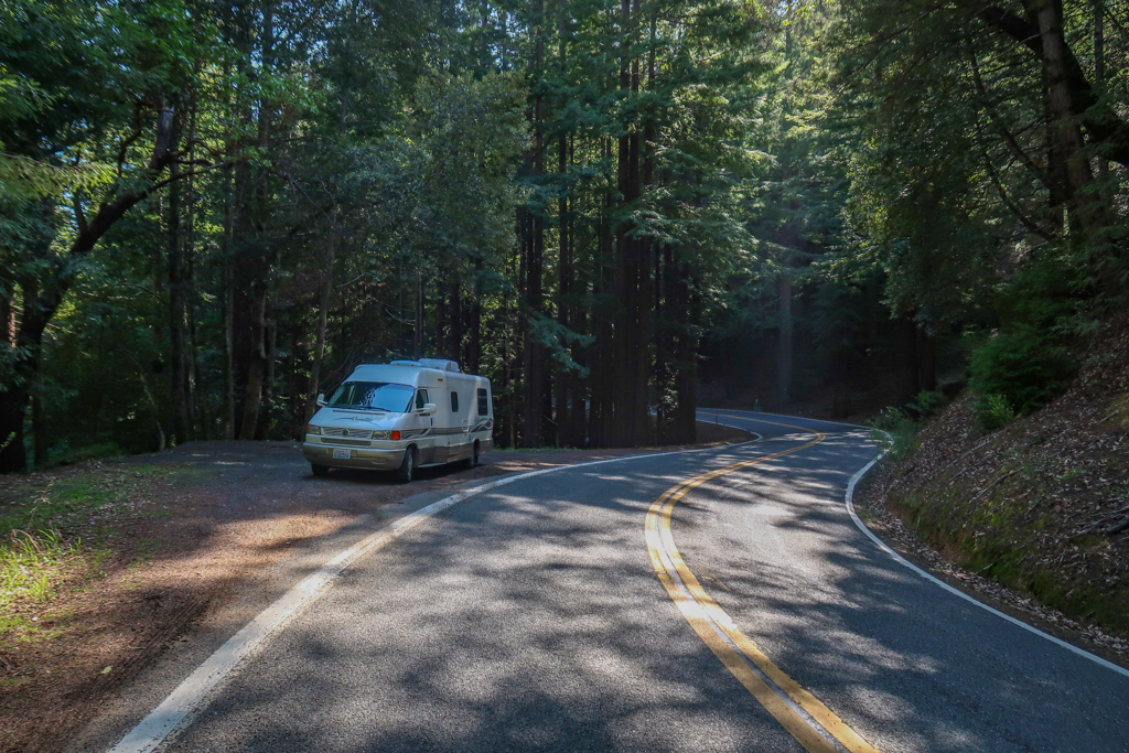 Our 21-foot RV, Appa, parked on the side of a curving road in the woods on Highway 1