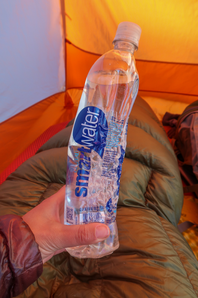 A 1 liter Smart Water bottle that is warped and wrinkled from having hot water poured into it.