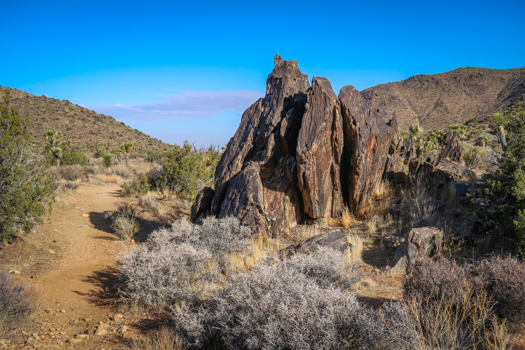 A dark jagged rock formation along to the right of the California Riding and Hiking Trail.