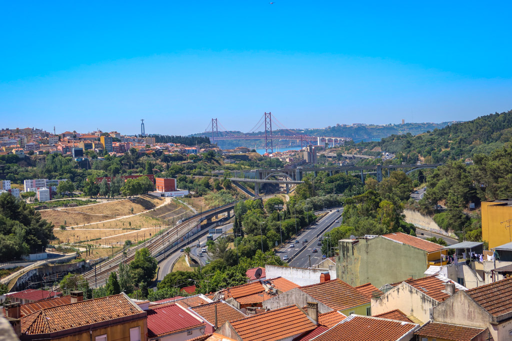 View of the brightly-painted red 25 de Abril suspension Bridge from the Ãguas Livres Aqueduct