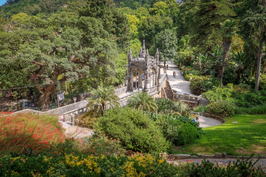 A path leads to an ornate gazebo surrounded by trees and other exotic plants