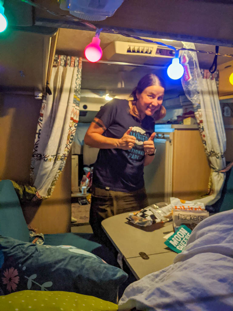the author stands inside the Rialta motorhome near the back dinette seats and folding table
