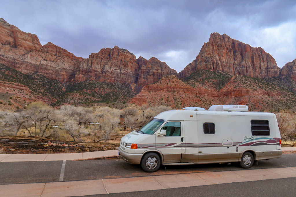 Appa parked along the road in Zion National Park, framed by steep red cliffs in the background