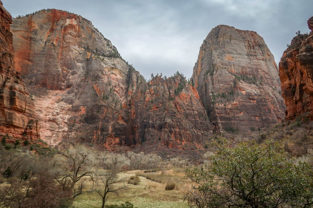 A tall mesa stands alone along the Zion Canyon walls, mostly composed of whitish-colored sandstone