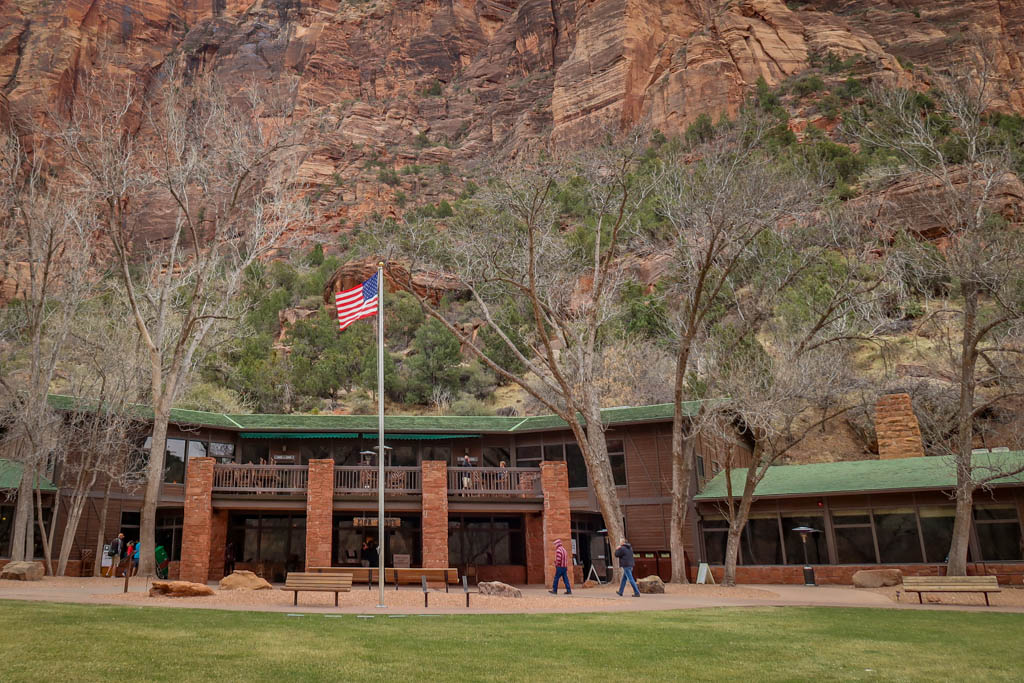 The front of Zion Lodge, a long two-story building nestled against bottom of Zion Canyon