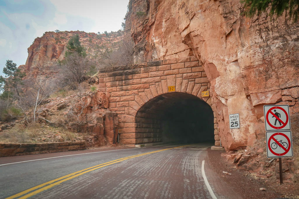 The road enters to a tunnel blasted into the side of a cliff in Zion National Park. Maximum height of 13'2".